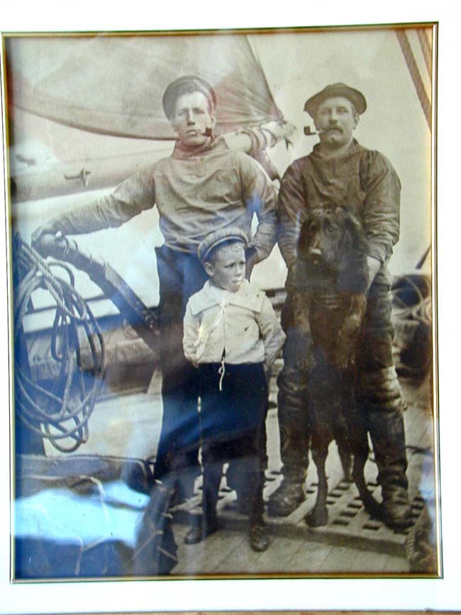 A Late 19th century Photograph of Two Sailors, a Boy and a Labrador Retriever at the Helm of a Ship — image 2