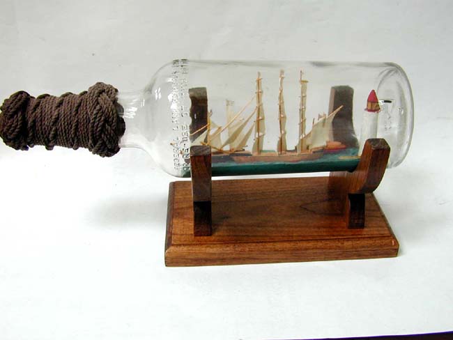 A Mid 20th century Ship-in-a Bottle Featuring Three Ships and a Lighthouse