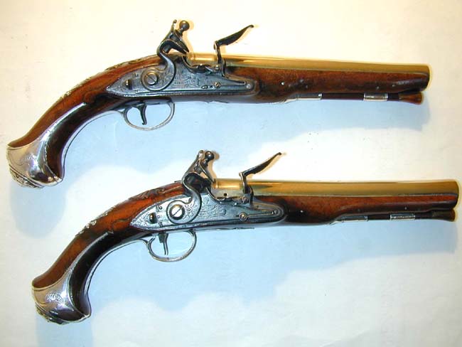 A Nice Pair of Silver-Mounted Flintlock Holster Pistols with Brass Barrels signed 'J. Henshaw, London,' one hallmarked 1749, the other 1754
