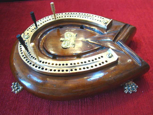 A wonderful English mahogany and brass horseshoe shaped cribbage board made circa 1890