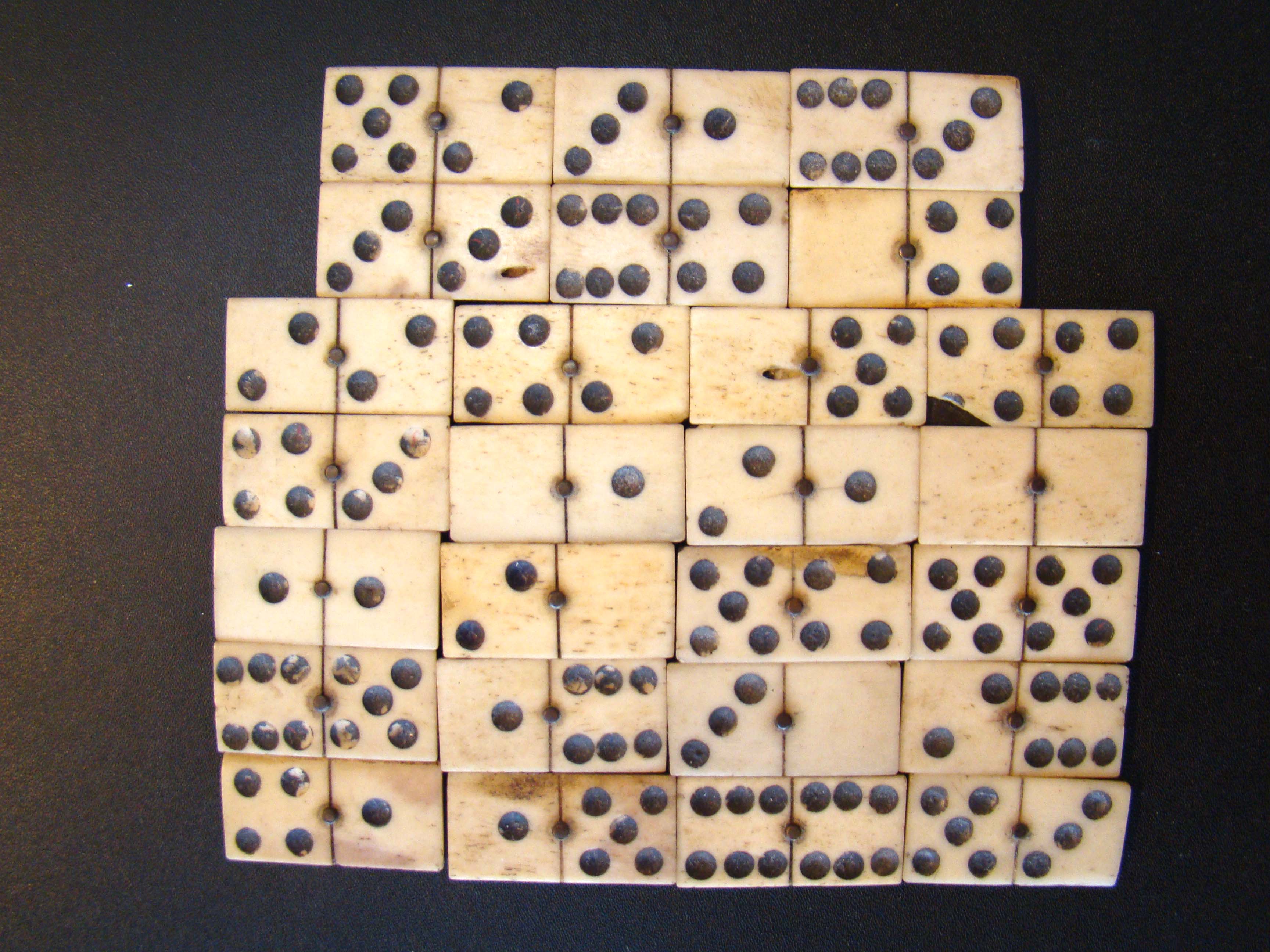 A group of 26 hand-cut Civil War era bone and ebony dominoes circa 1865