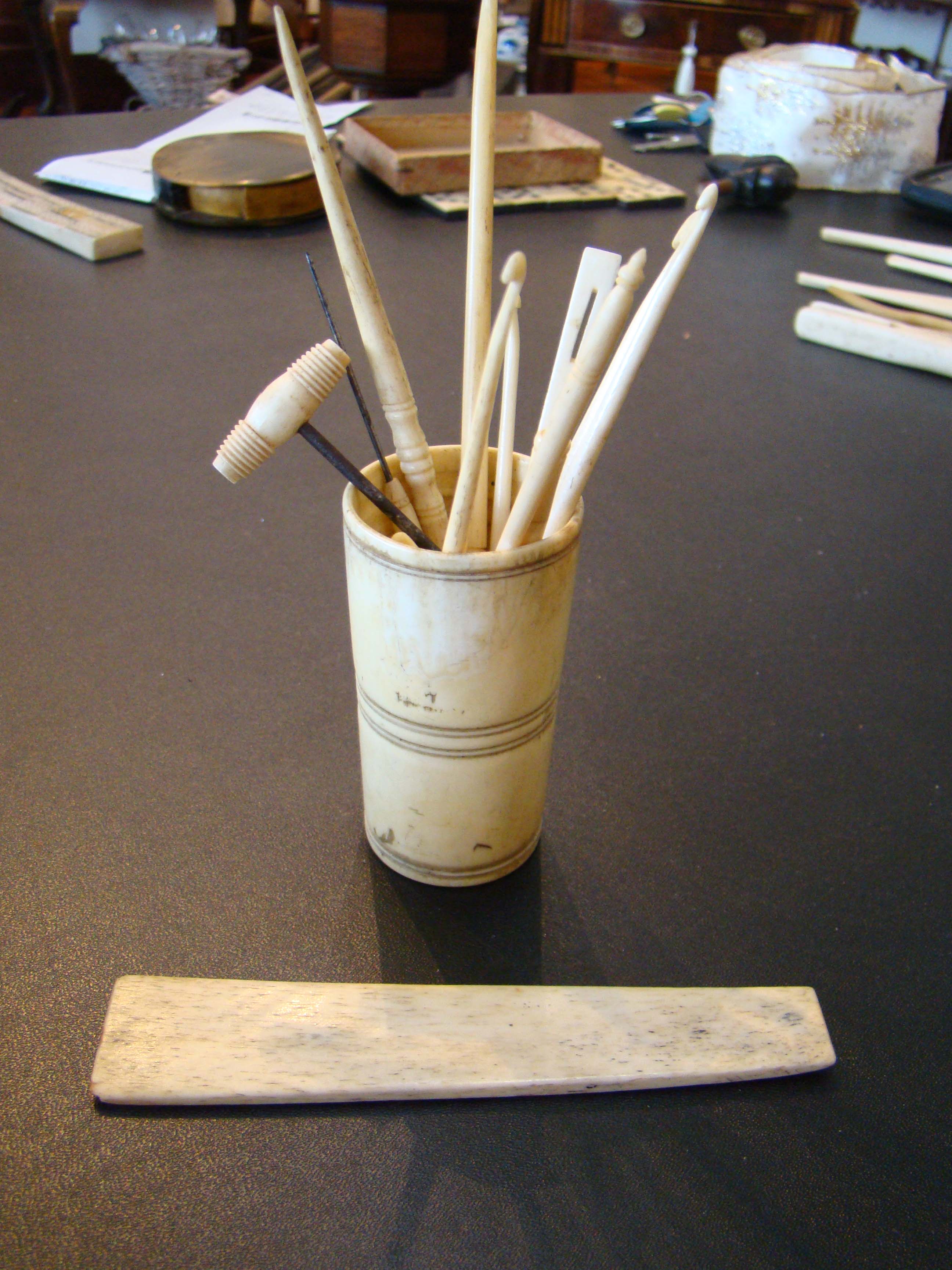 A group of 19th century whalebone sewing implements along with a whalebone cup