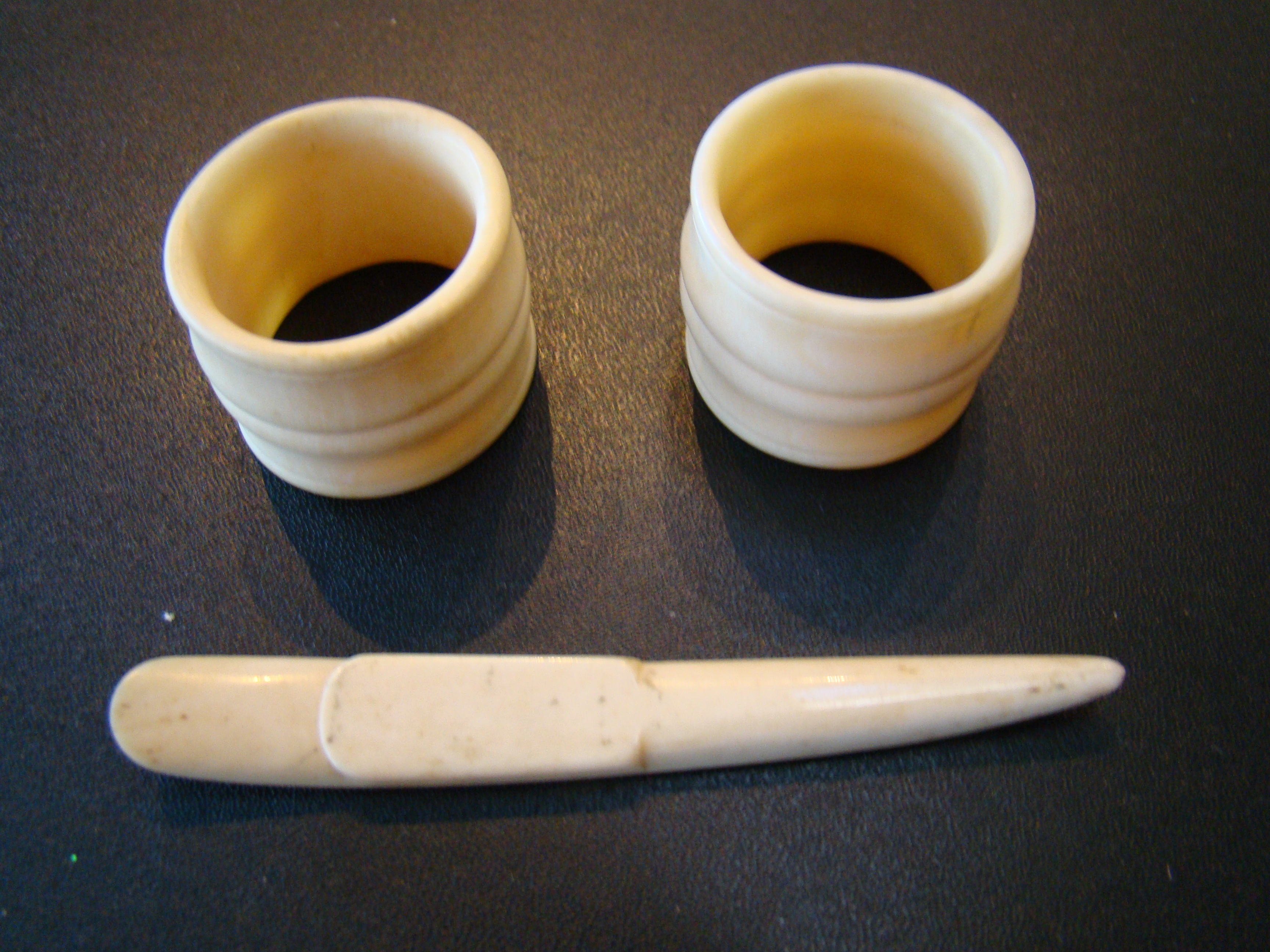 A pair of 19th century whalebone napkin rings together with a small whalebone implement