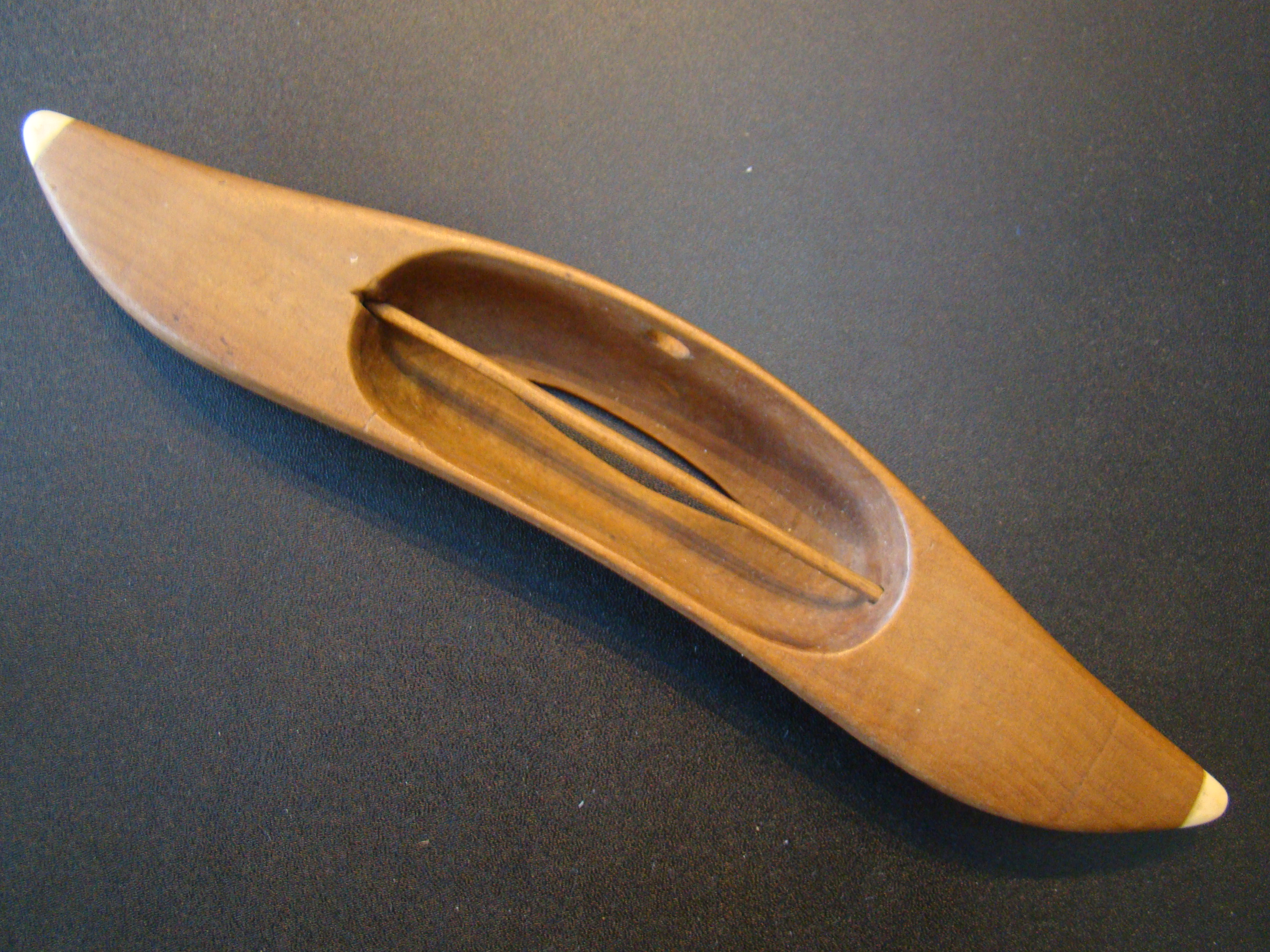A beautiful 19th century hand carved sewing or weaving shuttle with whale ivory tips