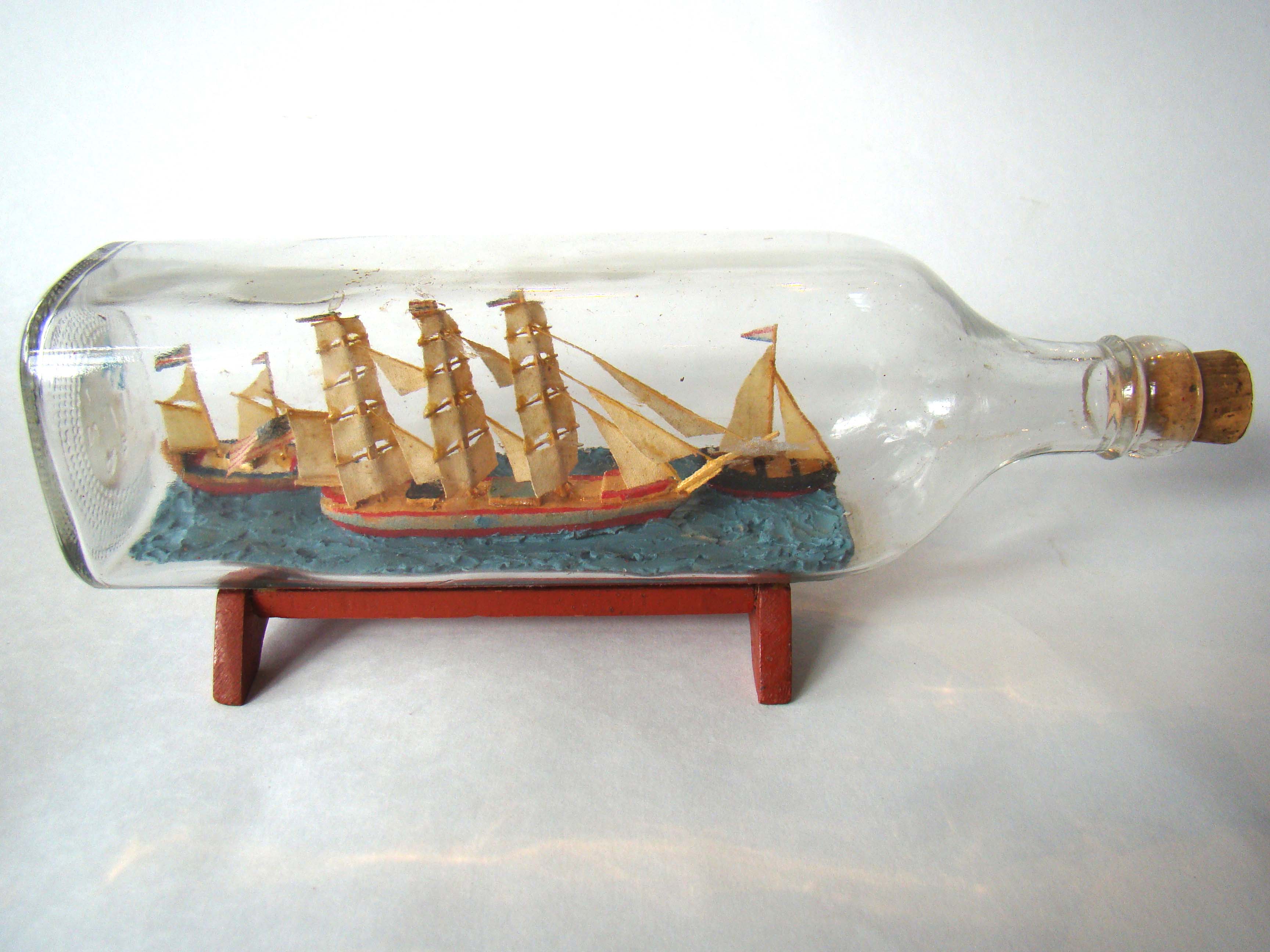 An early 20th century ship-in- bottle with 3 ships featured