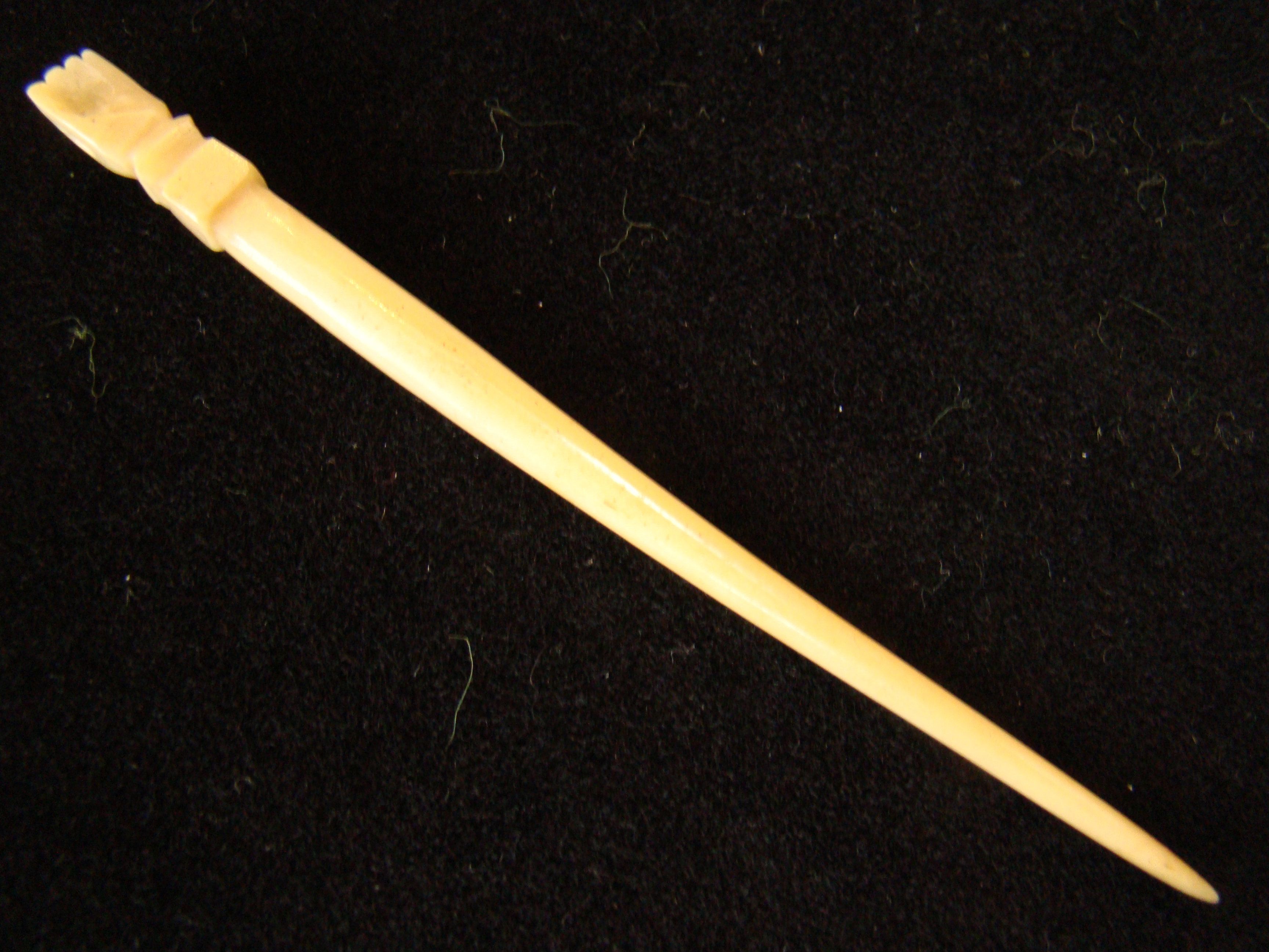 A 19th century whalebone bodkin or fid with open hand knob measuring 7 1/2" long