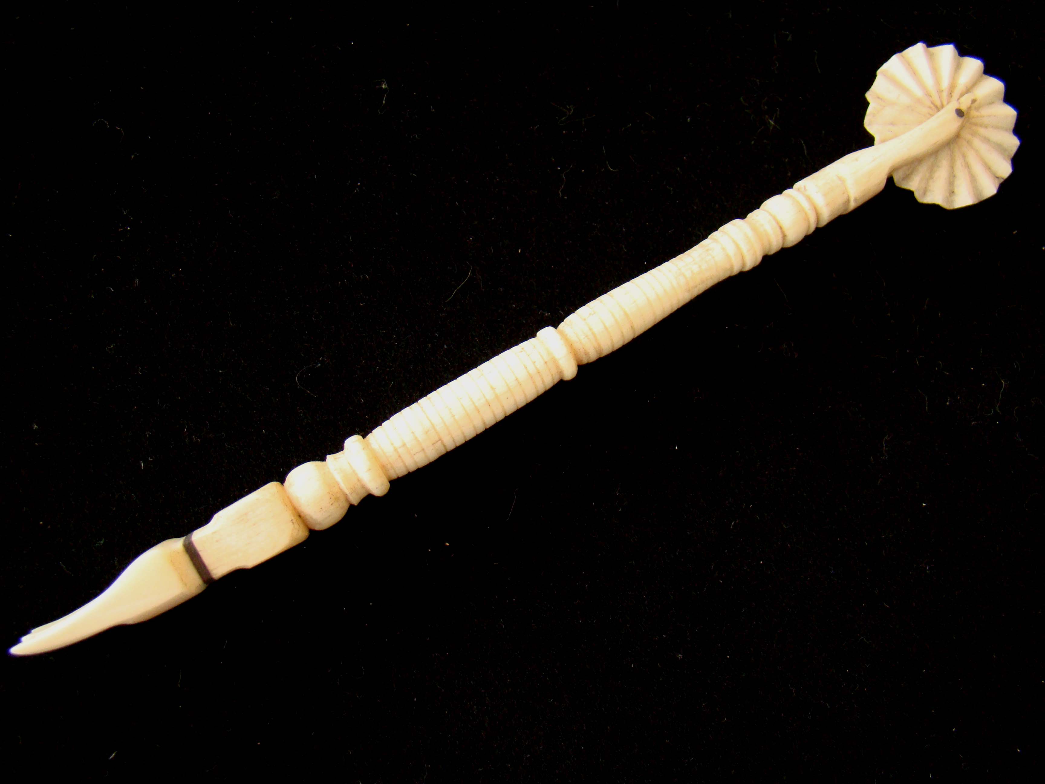 A 19th century sailor-made scrimshaw pie crimper with fork on the opposite end