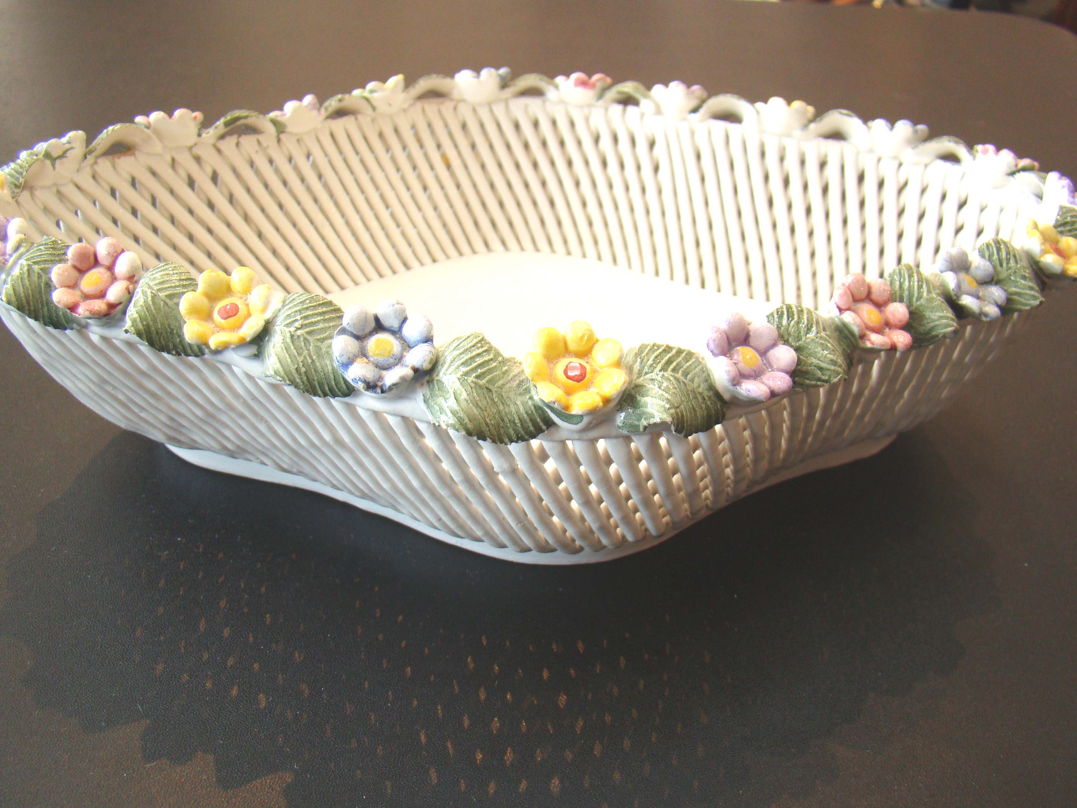 An attractive Italian made basket weave pottery bowl with applied flowers around the rim