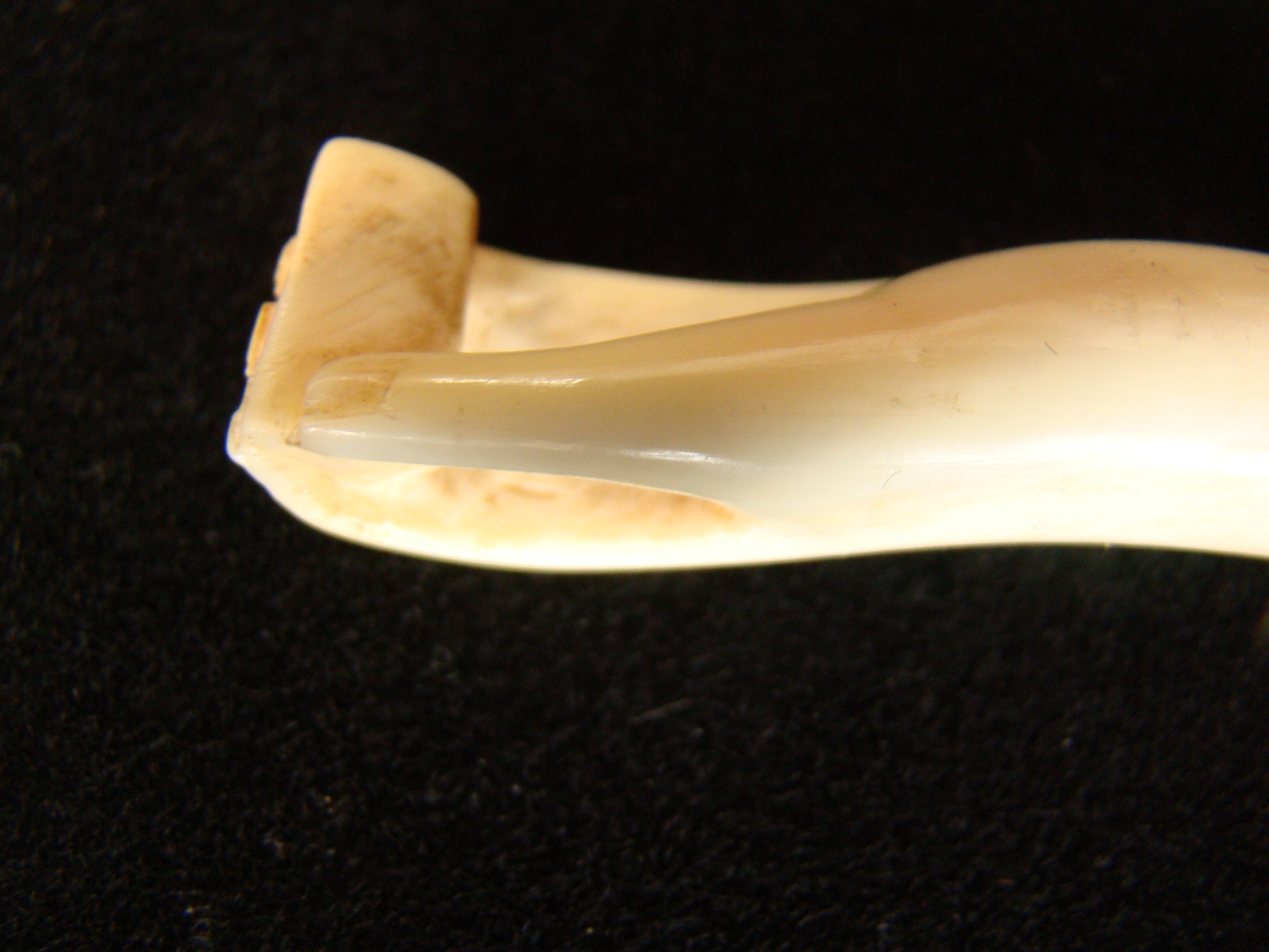 A sailor -carved whale ivory bodkin depicting a hand holding a small box or book circa 1850