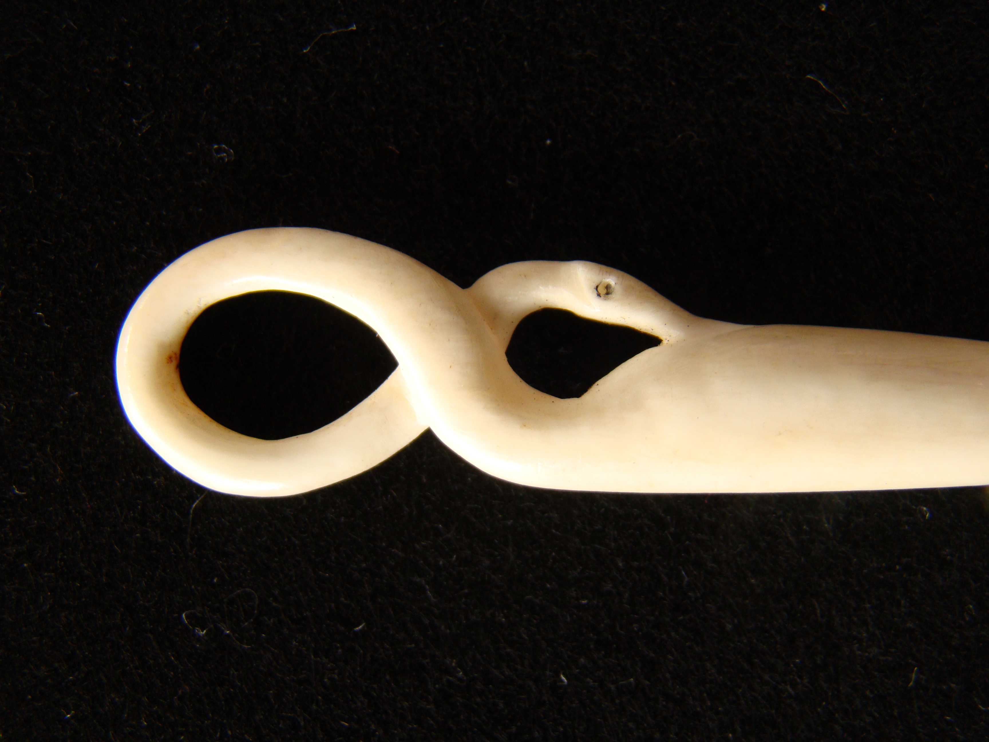 A fine whale ivory bodkin in the form of a coiled serpent circa 1850