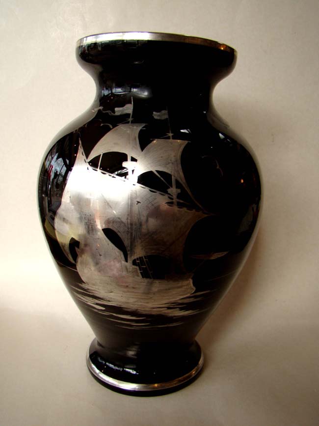 An attractive vintage black glass vase with silver overlay scene depicting a 17th century ship