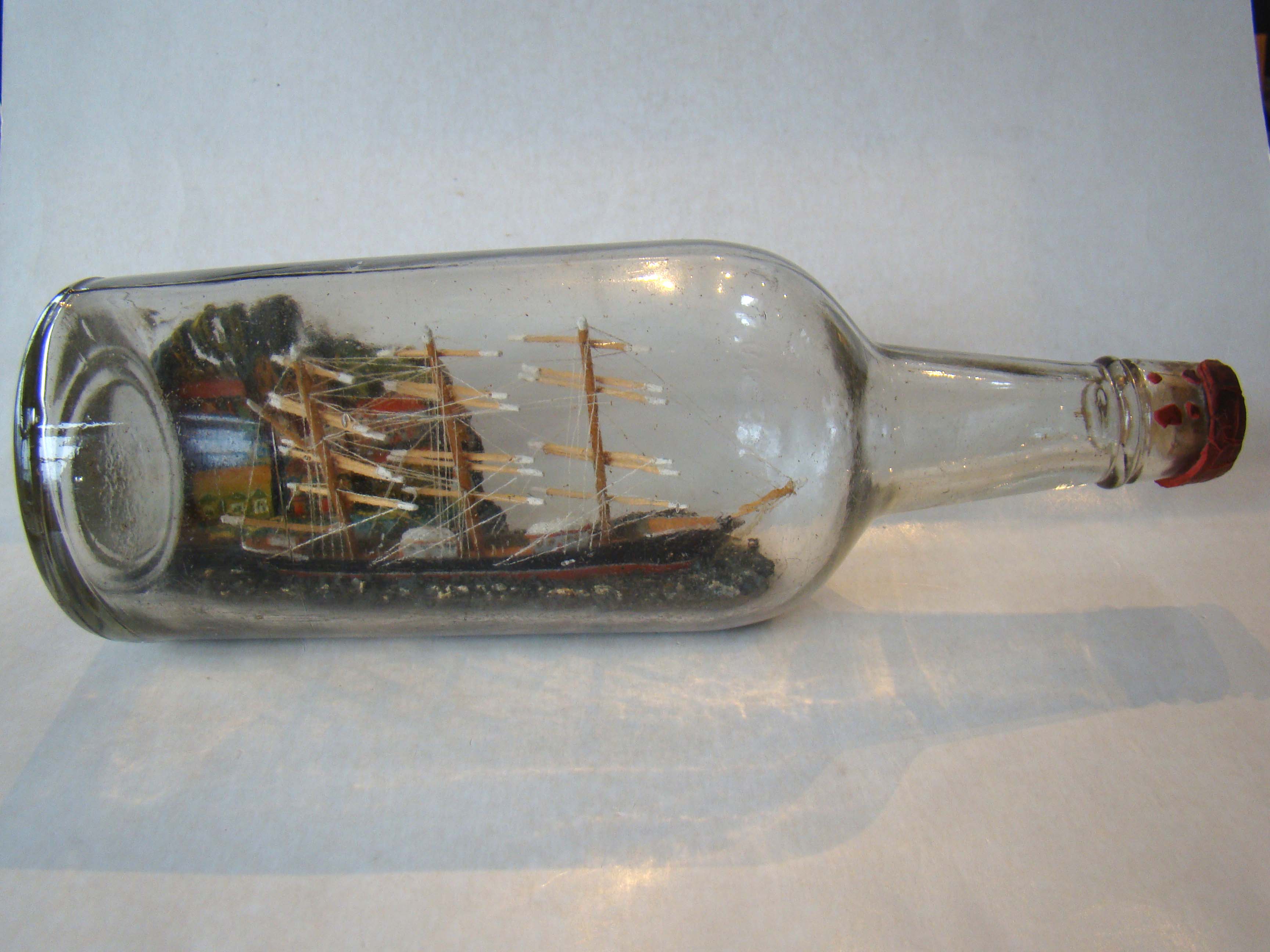A late 19th century ship-in-a bottle with a wonderful village scene in the background