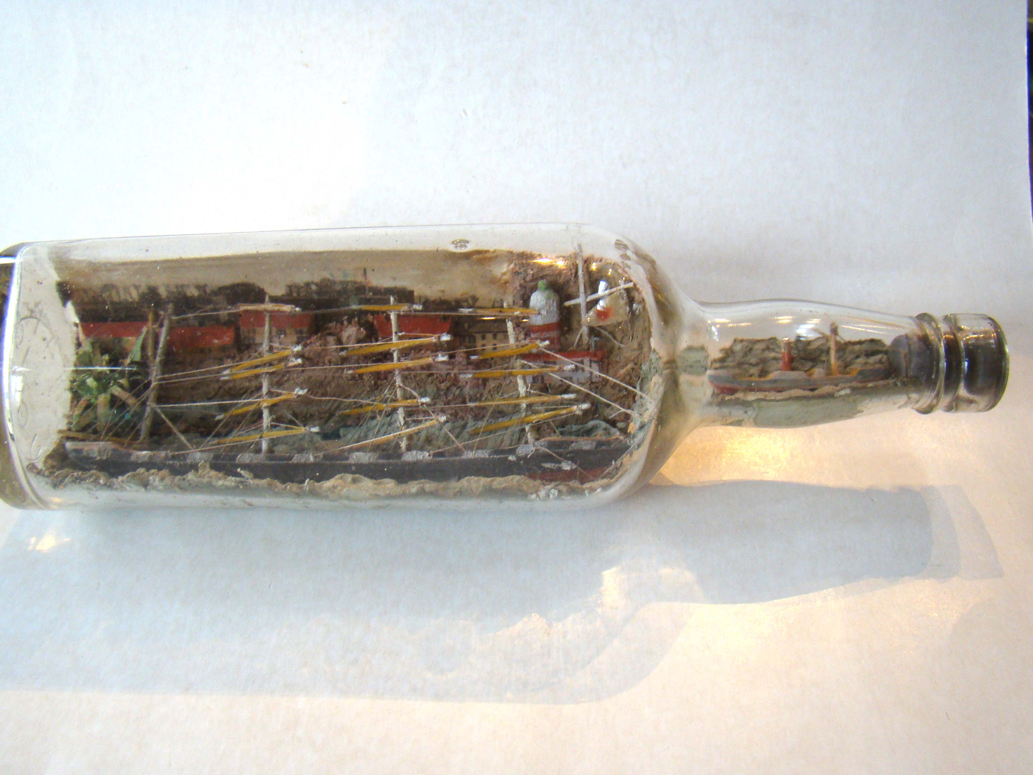 A rare early 20th century four-masted ship-in-a bottle with another smaller ship in the neck of the bottle. Circa 1900-1910.