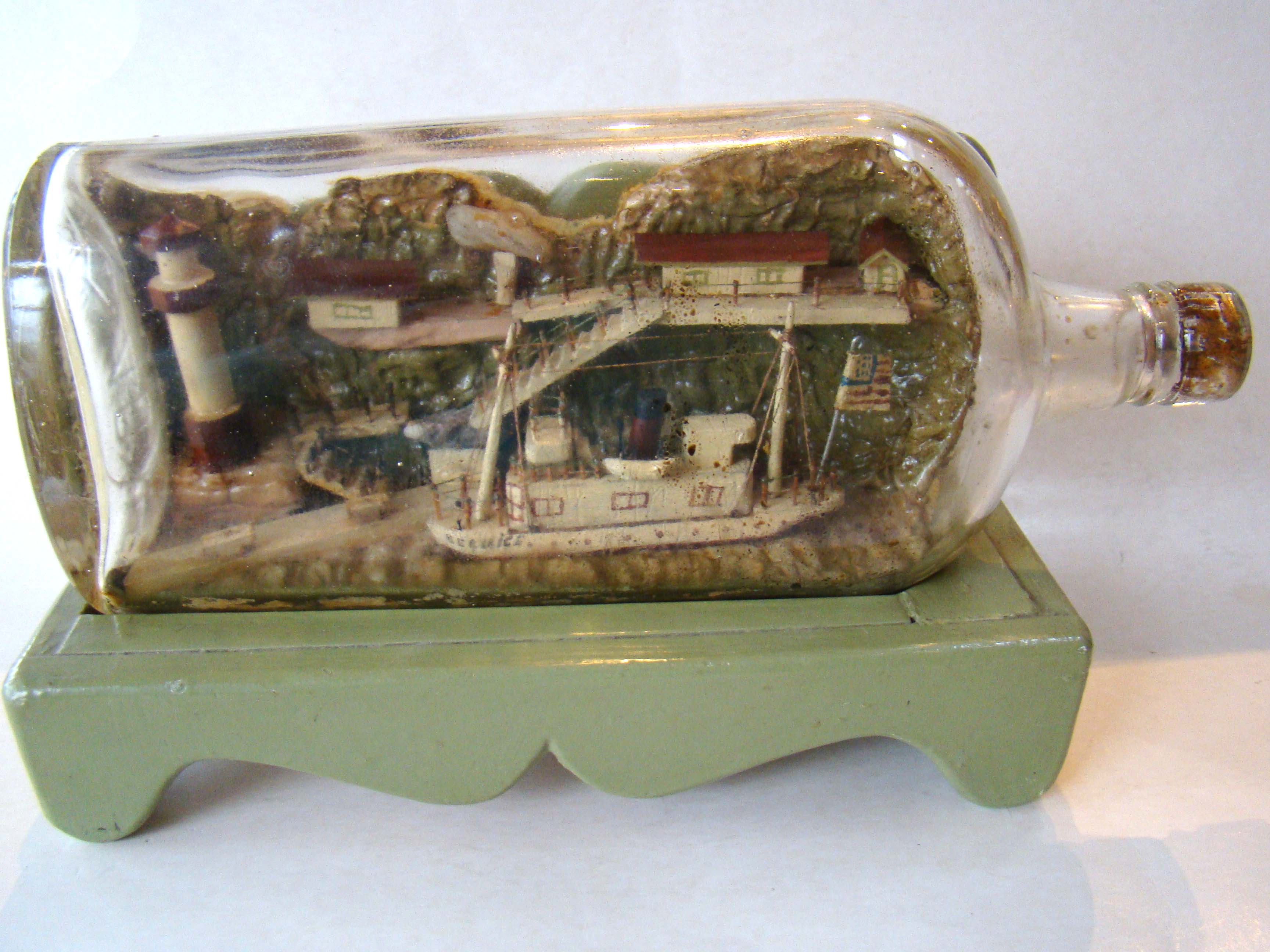 A large late 19th / early 20th century ship-in- bottle on an early custom made painted stand