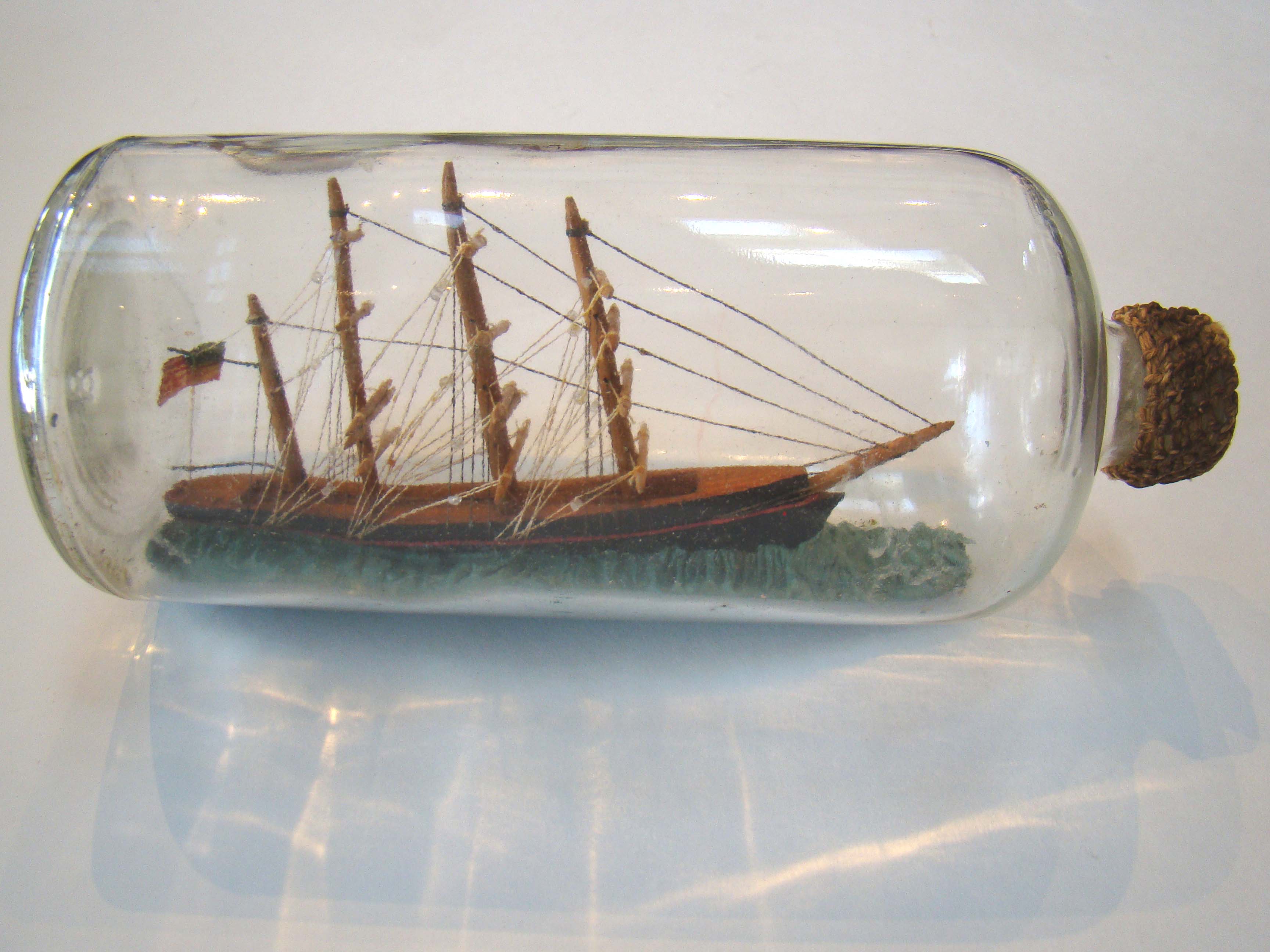 A fine vintage three-masted ship-in-a bottle flying an American flag circa 1920-1940
