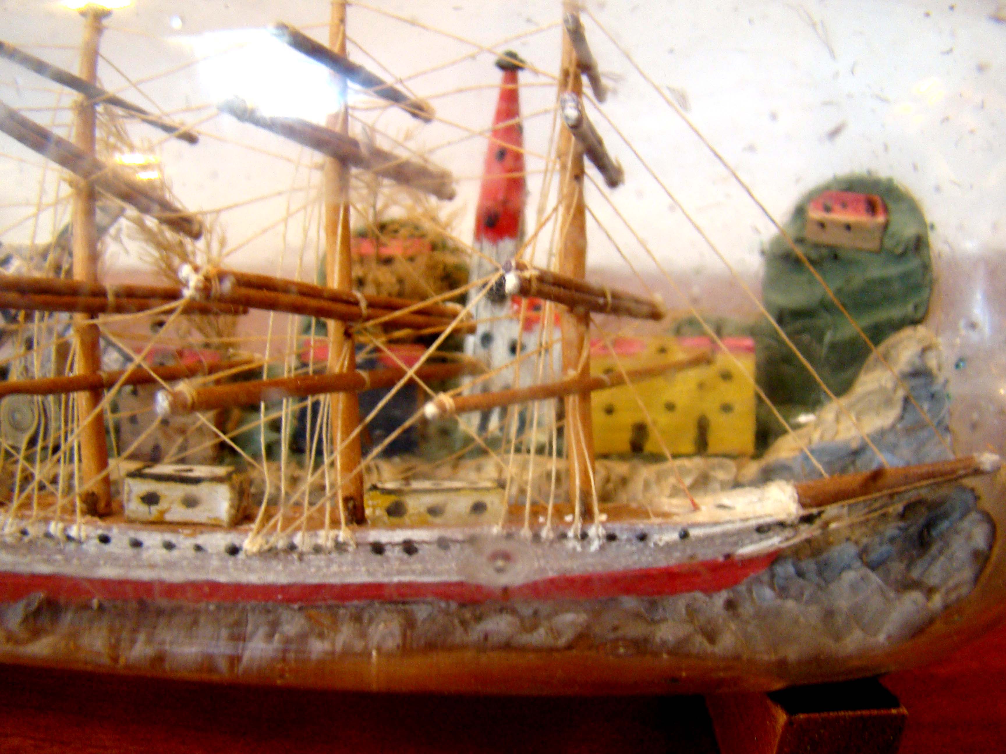 A fine vintage four-masted ship-in a bottle flying the American flag  with a charming village in the background circa 1900-1920   — image 3