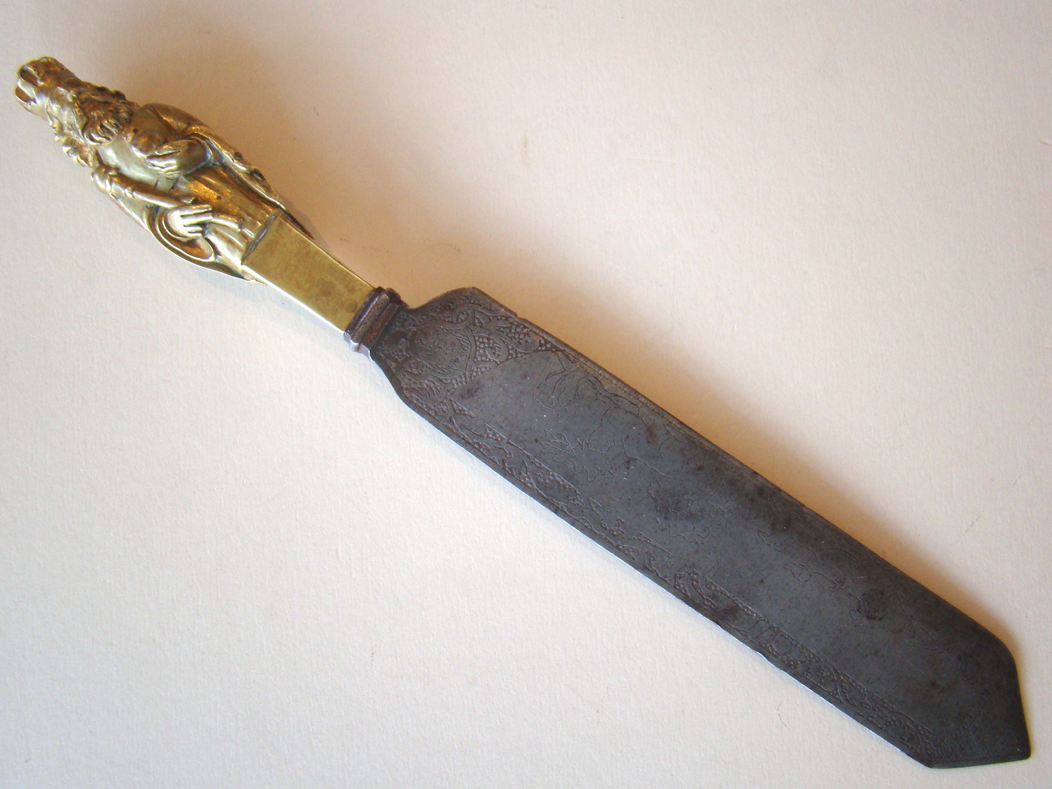 A RARE ceremonial knife, possibly 17th century, having a brass handle featuring a King holding his orb and sceptre