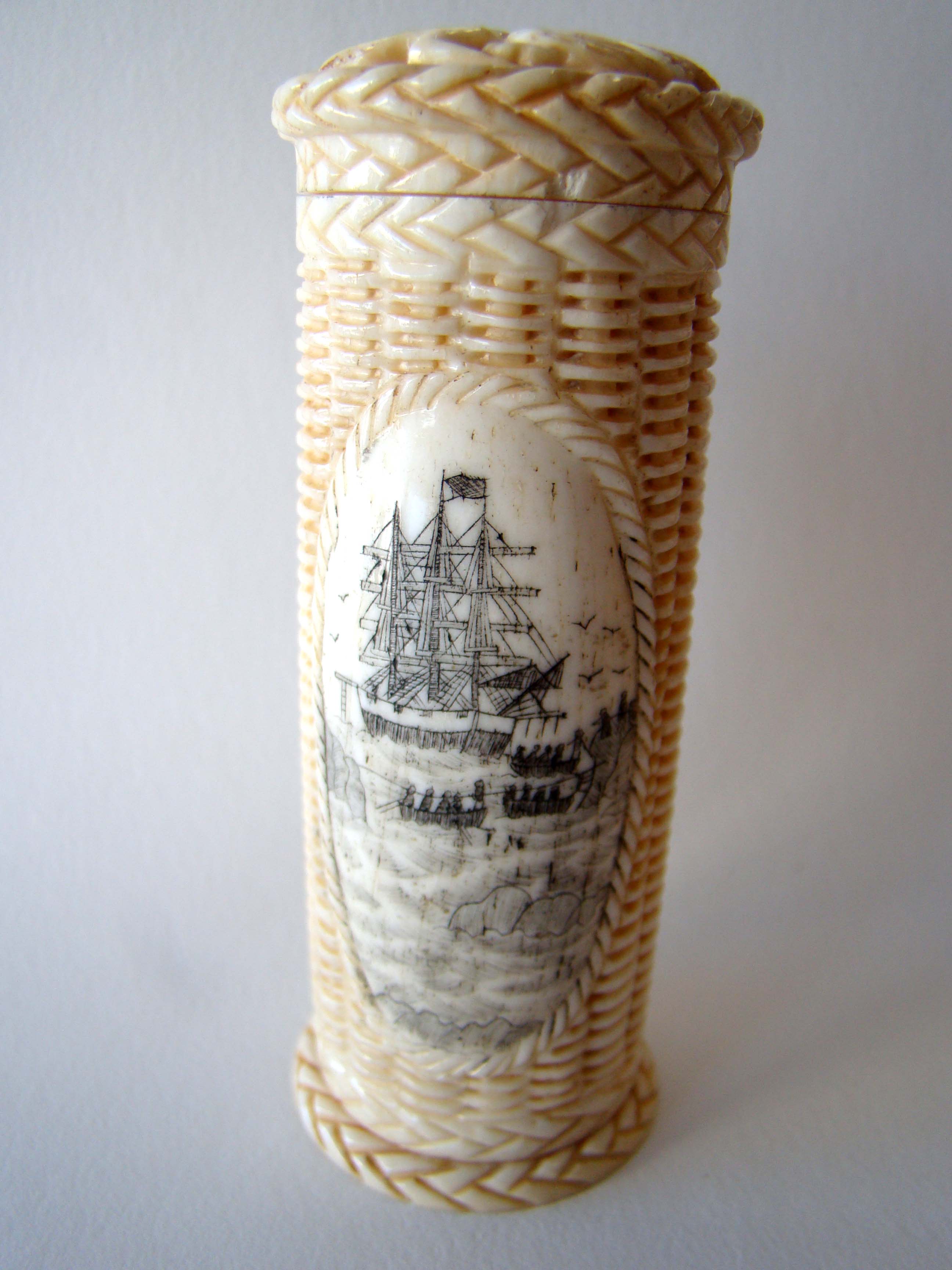 An attractive basket weave bone cylindrical container with whaling scenes and love birds on the lid. 20th century