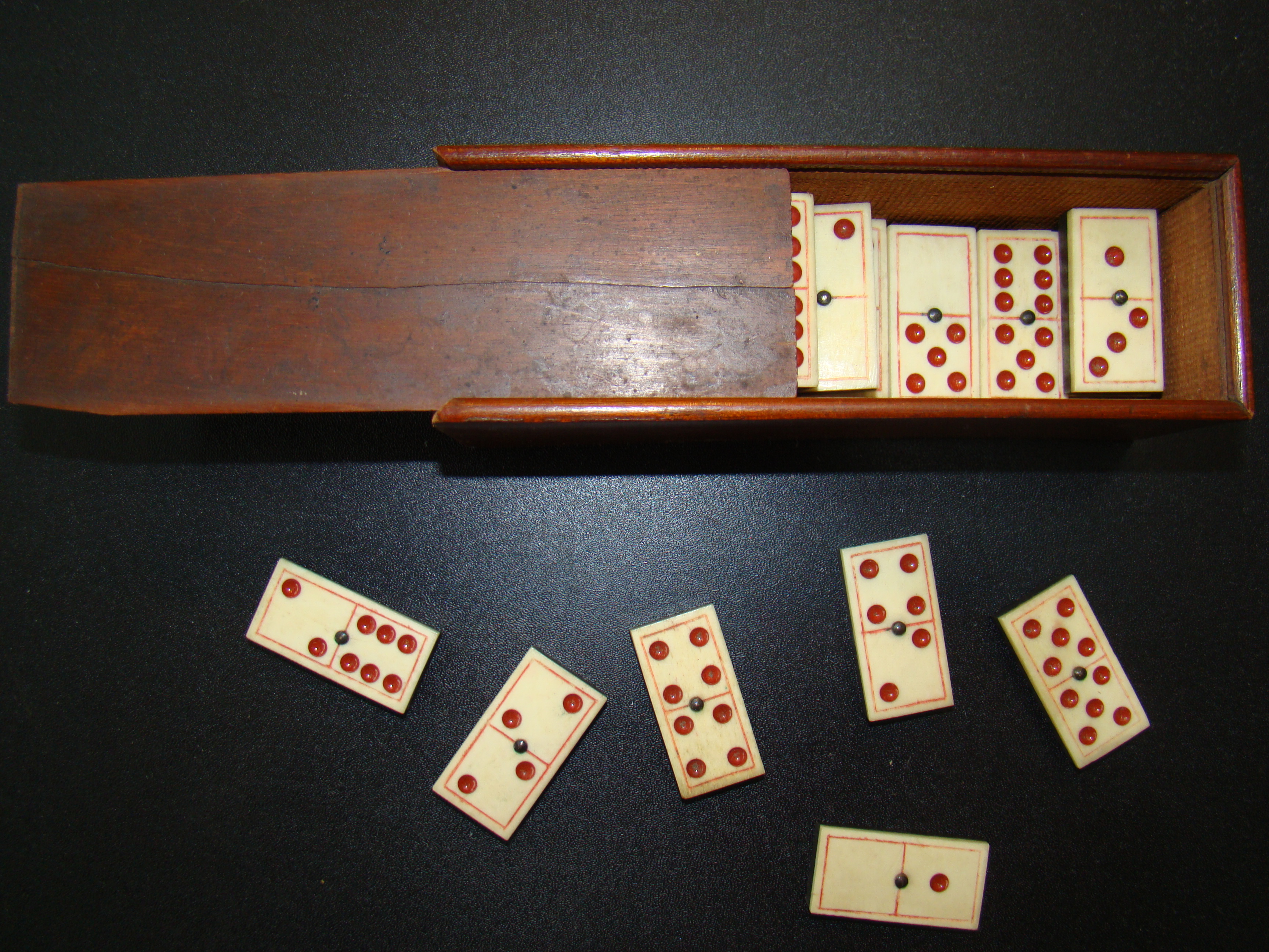 A fine and complete set of 28 bone and ebony dominoes with red dots and borders circa 1880 — image 2