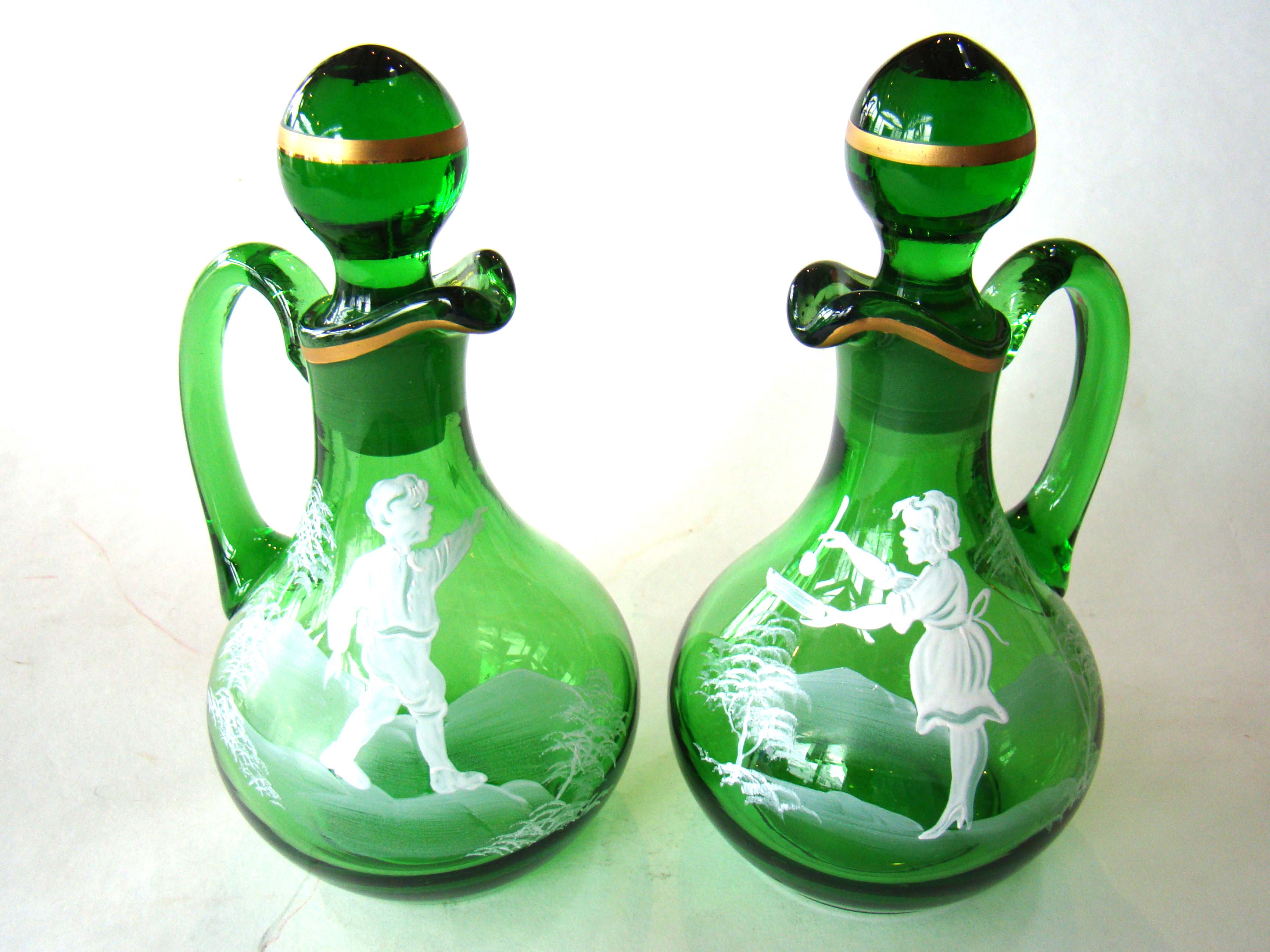 A fine pair of antique emerald green glass "Mary Gregory" (1856-1908) cruet bottles