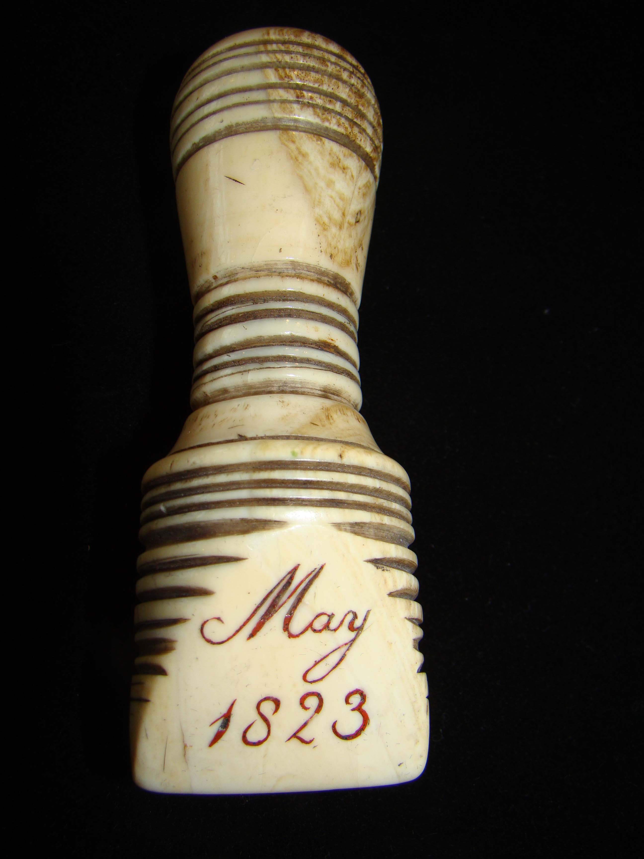 A beautiful sailor carved seam rubber made from a whale's tooth and inscribed "Mary 1823"