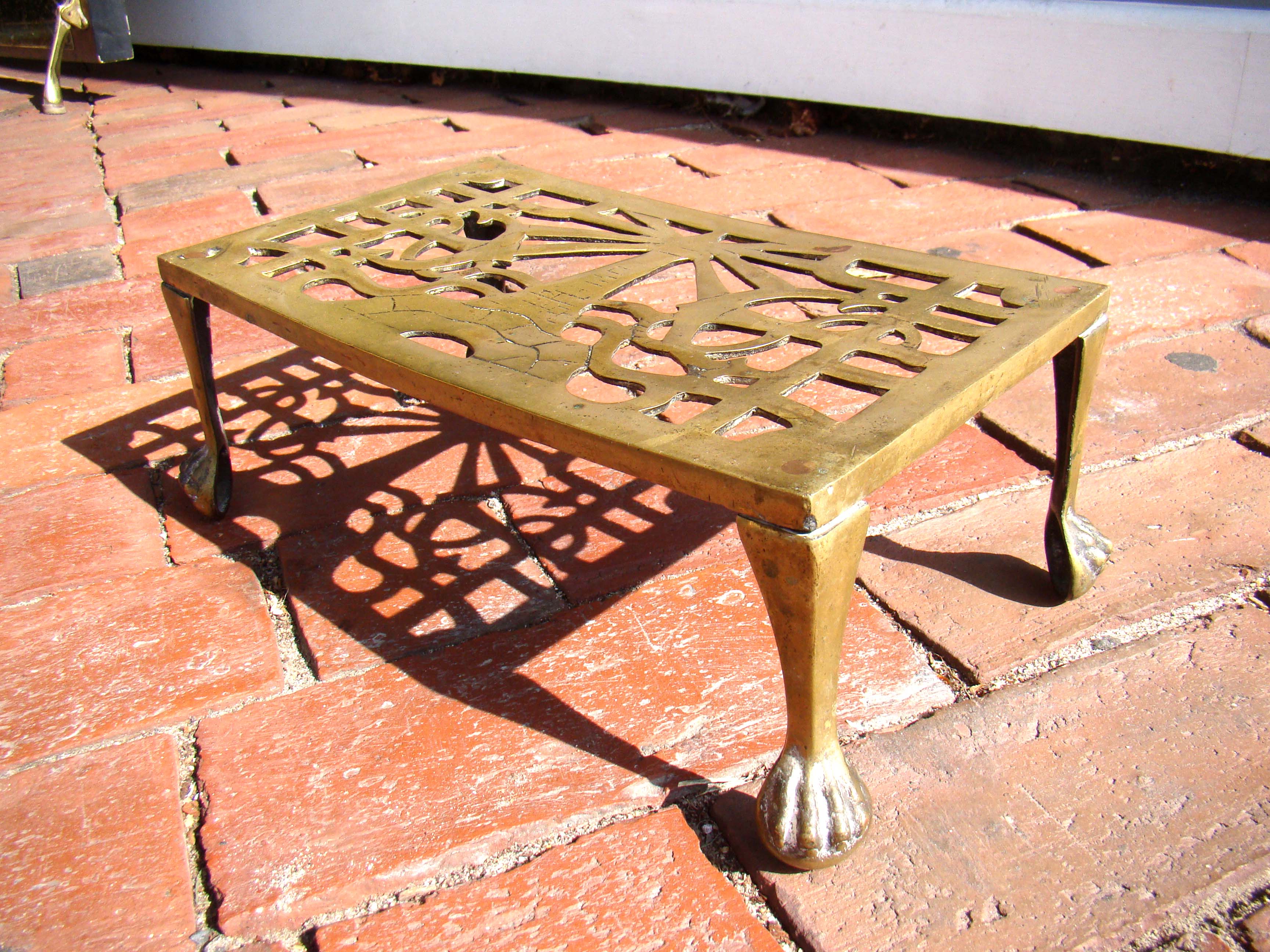 An antique nautical themed brass footman with lighthouse flanked by anchors circa 1820