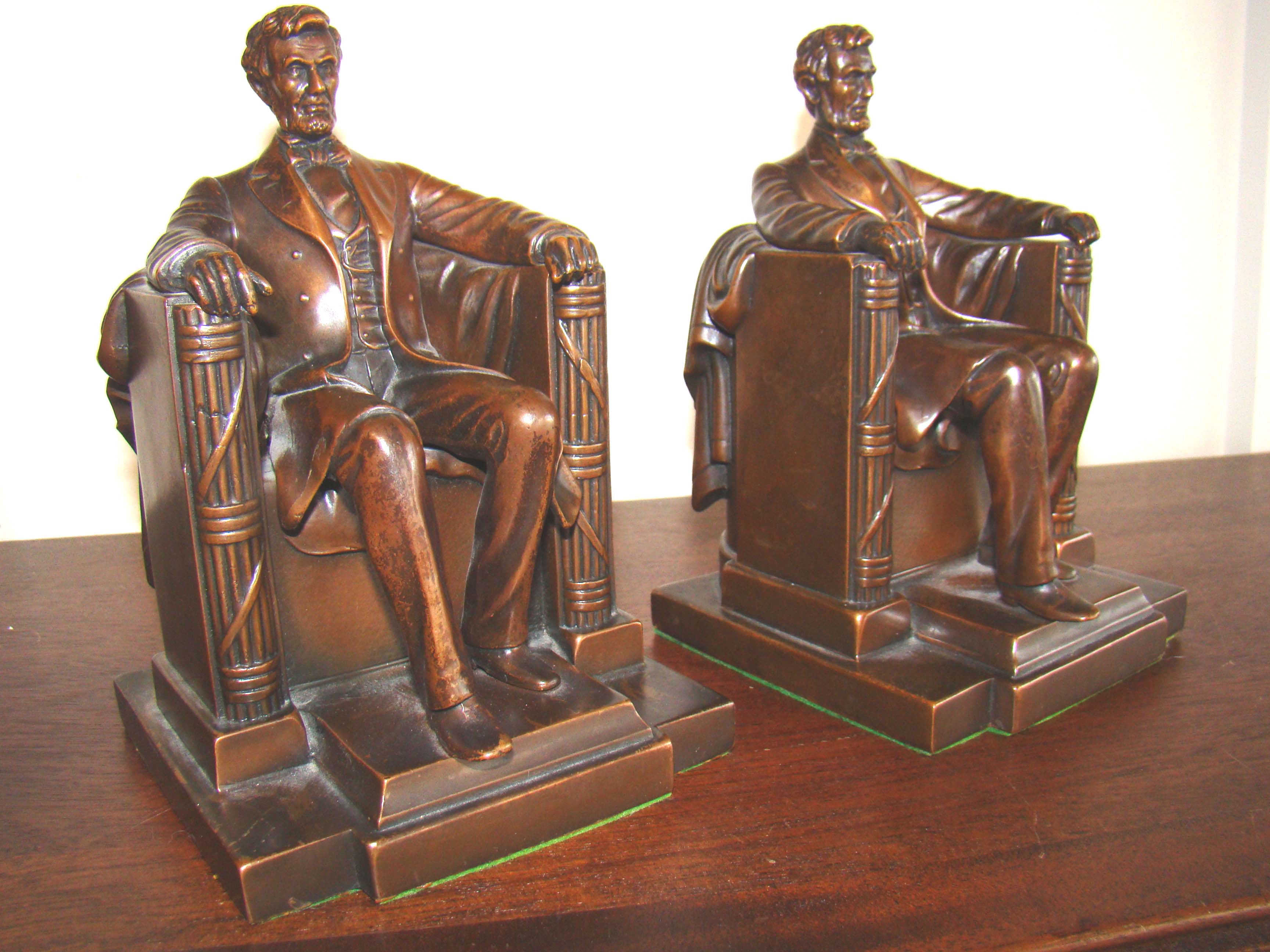 A gorgeous pair of chocolate brown, bronze Abraham Lincoln "sitting in the chair" bookends