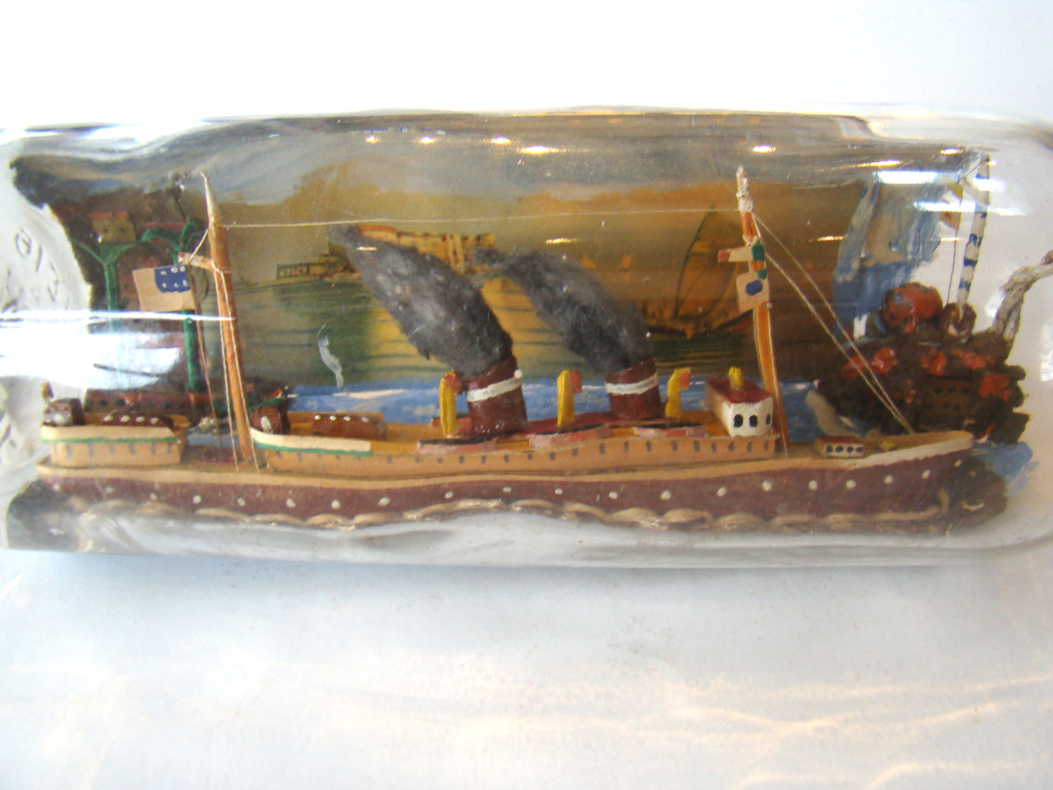 A fine vintage sailor-made two-funnel steam ship flying an American flag with village scene in the background