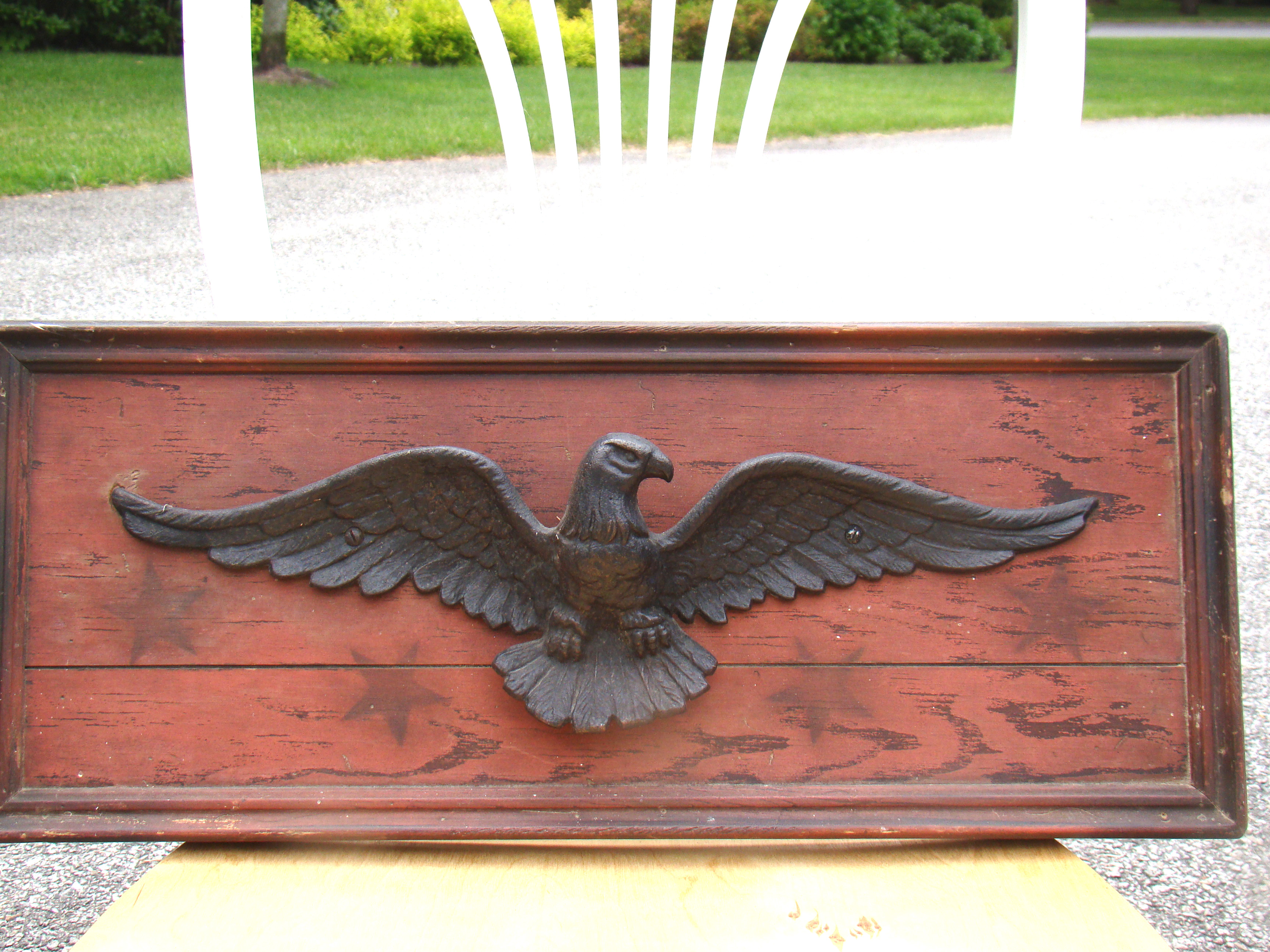 A vintage spread wing eagle mounted on a painted backboard, 19th century