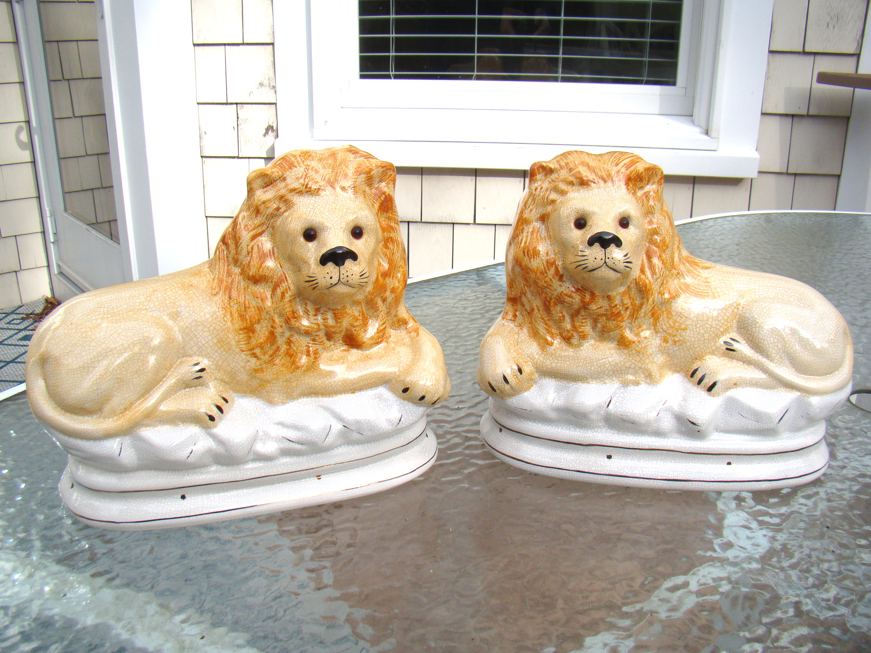A fine pair of 19th century English Staffordshire glazed lions with glass eyes