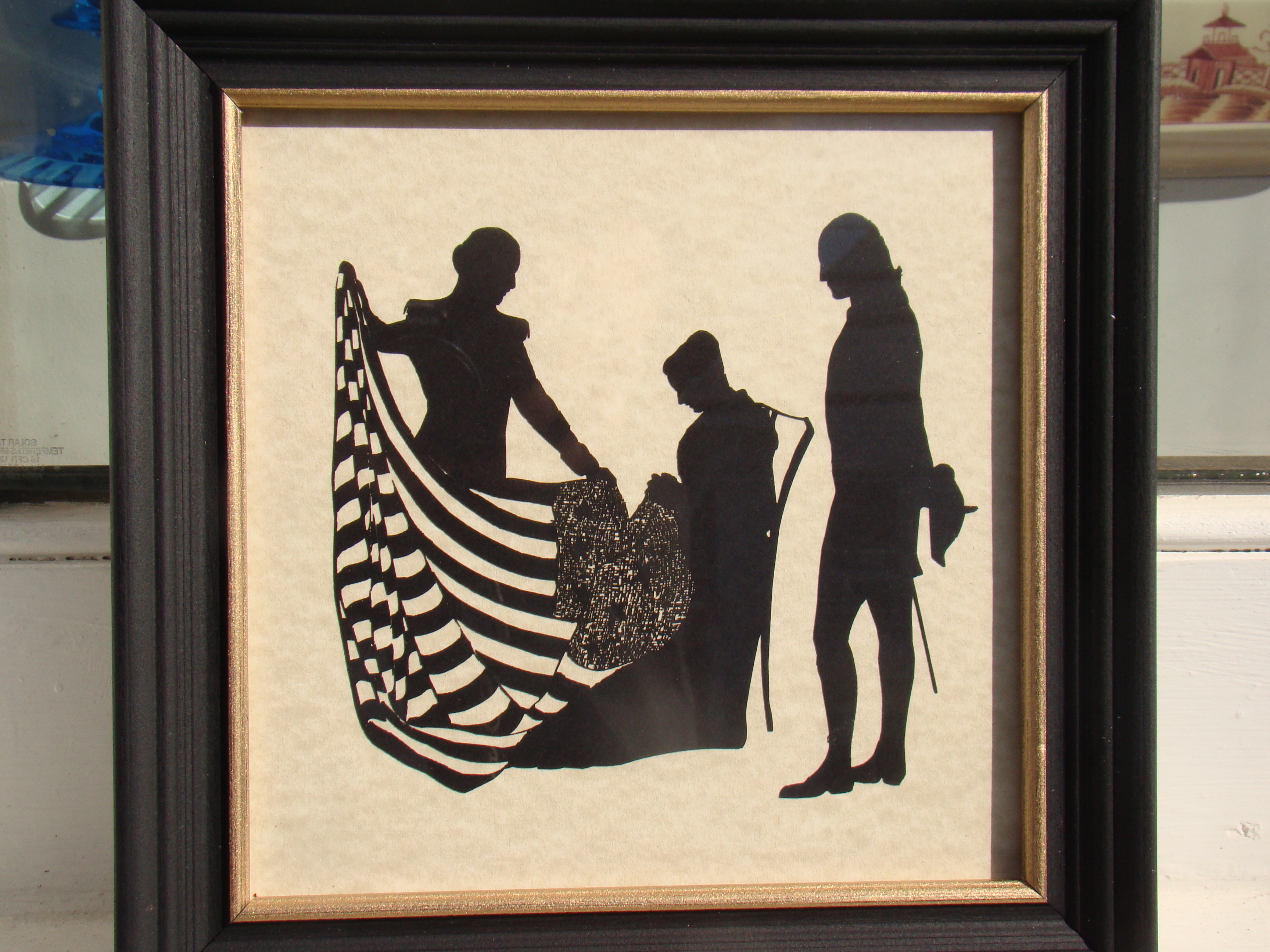 A charming contemporary silhouette depicting George Washington standing with Betsy Ross as she sews the first American flag