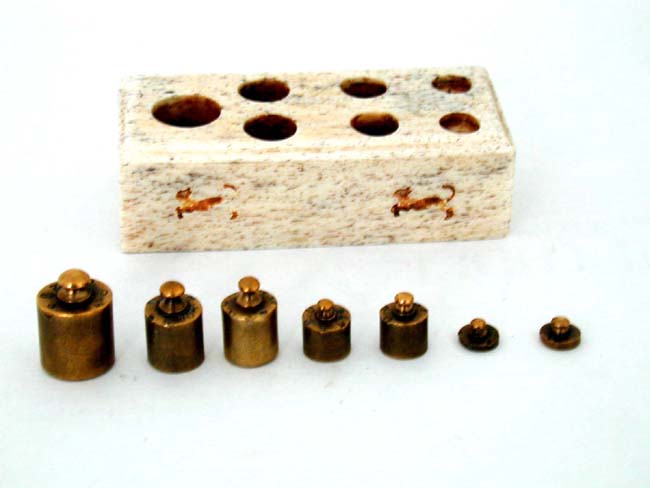 A Set of 19th century Brass Weights set into a Whalebone Stand